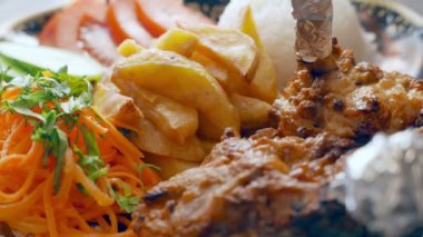 Kızarmış et, patates, pirinç ve sebze salatası.