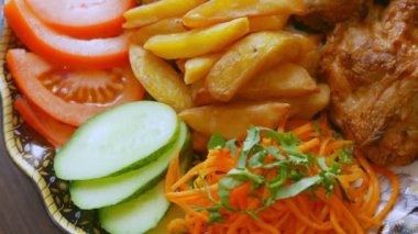 Kızarmış et, patates, pirinç ve sebze salatası.