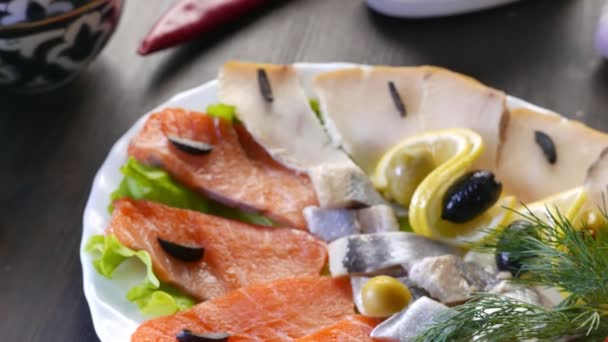 Seafood on plate - salmon, herring fish and sliced fish fillet — Stock Video