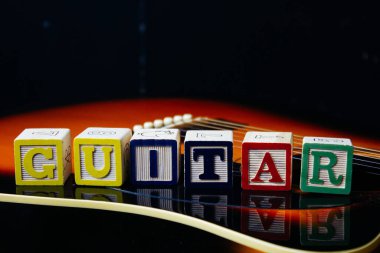 Gitarın üzerinde duran harf küplerinden yapılmış bir kelime ya da cümle..