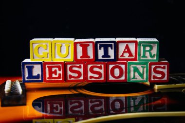 Gitar derslerinin kelime ve cümleleri gitar küplerinin üzerinde duruyordu..