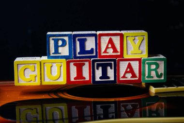 Gitarın üzerinde duran harf küpleriyle gitar çal..