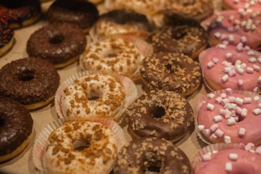 Donuts multicolored . Sale of sweets in a confectionery. Selective focus. top side view, blurred foreground.