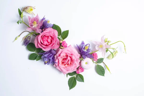 Festive floral background. floral layout of pink and violet aquilegia on a white background. Top view, flat lay. Flowers border and copy space.