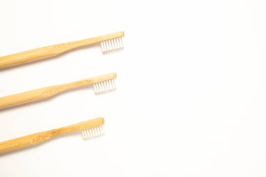 Three wooden toothbrushes on a white background, top view. Zero waste concept. 