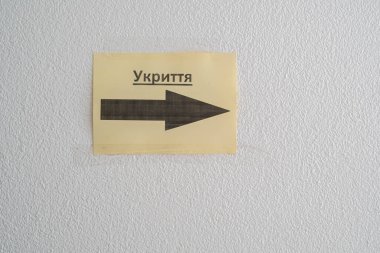 inscription Shelter in Ukrainian and a pointer in a multi-storey building. Military aggression of the Russian Federation against Ukraine. 