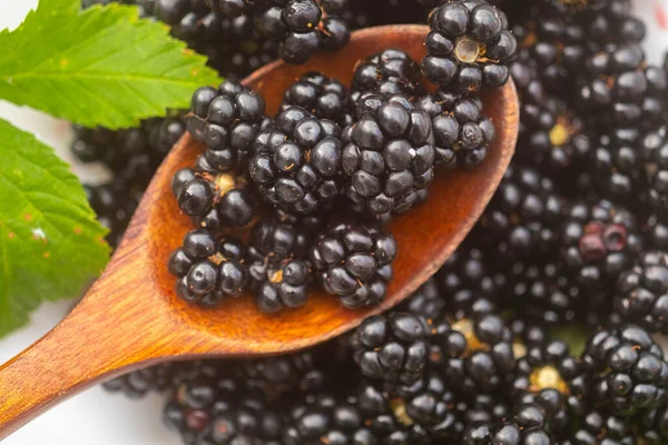 Closeup bramble in a wooden spoon. Full frame. Blur and selective focus