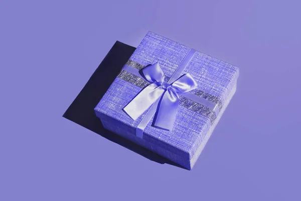 Blue gift on a purple background — Stock Photo, Image