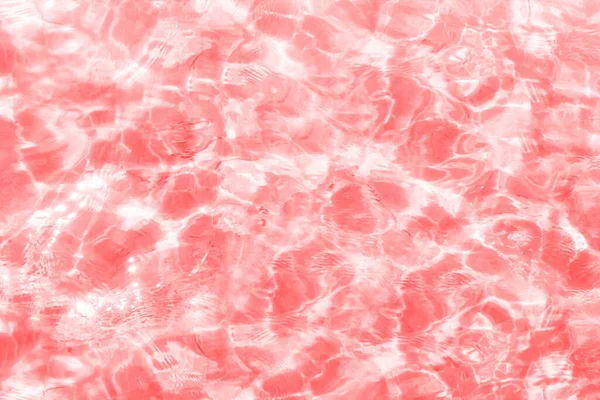 Defocused blurred clear red water. Sun glare and shadows in calm water. Trendy abstract nature texture background. Summer coolness. Copy space for text