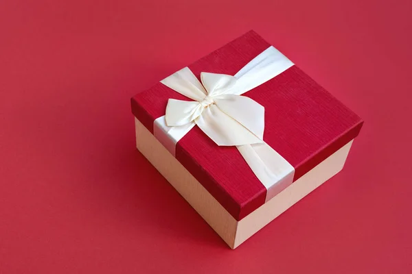 Kırmızı arka planda saten ışık kurdelesi olan güzel kırmızı hediye kutusunun üst manzarası. Noel için bir hediye, yeni yıl ya da romantik bir sevgililer günü. Metin için alanı kopyala.