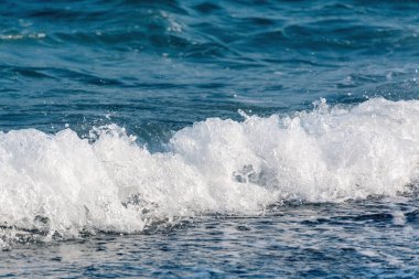 Mavi su ve köpüklü güzel bir deniz dalgası. Uzay iş seyahati ve eğlence konseptini kopyala.