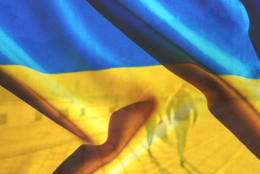 Çift kompozisyon. Ukrayna 'nın mavi ve sarı bayrağı ve güneşli bir günde şehirde yürüyen bir çiftin bulanık arkaplanı. Metin için alanı kopyala.