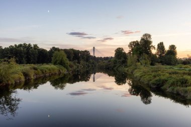 Şehir parkında bir nehir. Renkli Yaz Günbatımı.