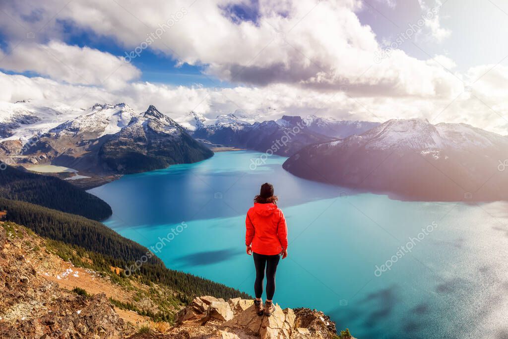Adventurous Caucasian Woman hiking on top of a Canadian mountain.