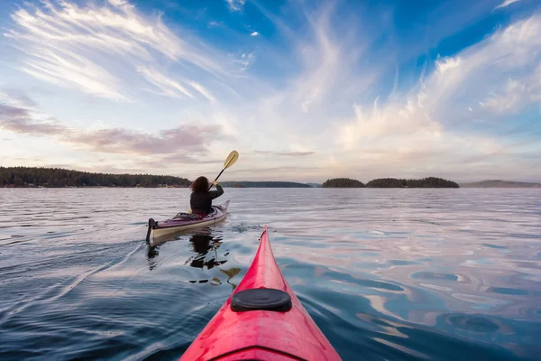 Avontuurlijke vrouw op zee kajakken peddelen in de Stille Oceaan. — Stockfoto