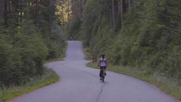 森の中のトレイルで冒険的な女性バイクに乗る — ストック動画