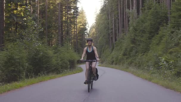 Mujer aventurera paseando en bicicleta por un sendero en el bosque — Vídeo de stock