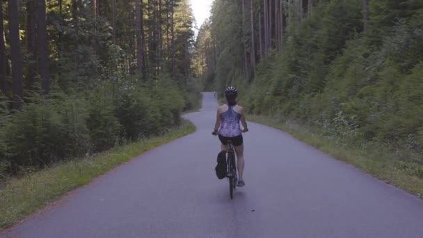 Mujer aventurera paseando en bicicleta por un sendero en el bosque — Vídeo de stock