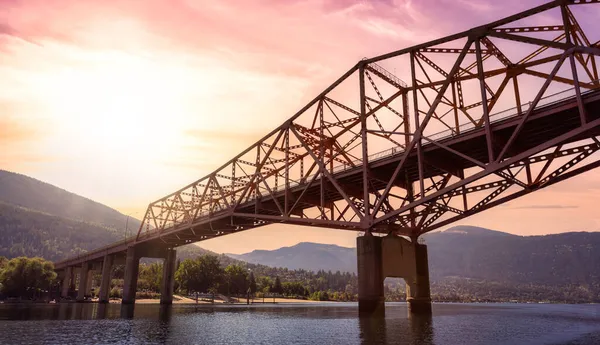 Grande ponte arancione sul fiume Kootenay con la città turistica sullo sfondo. — Foto Stock