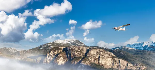 Bulutlu bir günde dağların üzerinden uçan uçaklar. — Stok fotoğraf