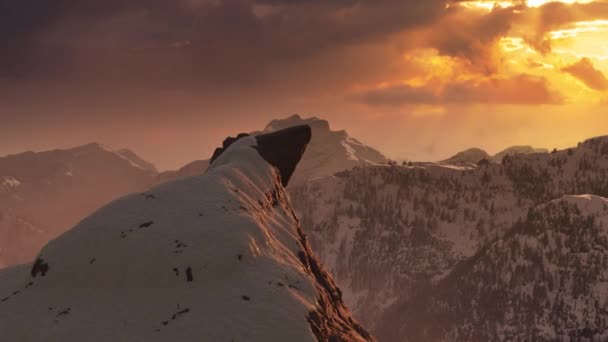 Snow on top of a rocky mountain peak with nature landscape in background. — Stock Video