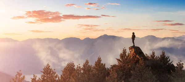 Kalandvágyó kaukázusi nő áll a Sziklás-hegy tetején. Sunset Sky Art. — Stock Fotó
