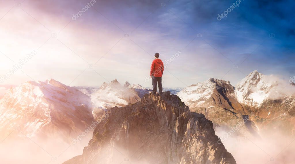Adventurous Man on top of a rocky mountain.