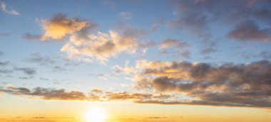 Renkli bir günbatımı sırasında bulutların panoramik görüntüsü