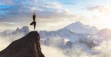 Beyaz Kafkas Yetişkin Kadın kayalık bir dağın tepesinde Yoga Pozu Veriyor.