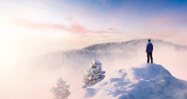 Yetişkin maceraperest bir adam bir kar zirvesinin üstünde duruyor..