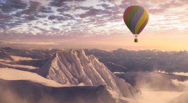 Dramatic Mountain Landscape covered in clouds and Hot Air Balloon Flyin