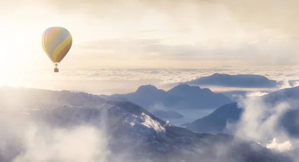 Dramatische berglandschap bedekt met wolken en hete lucht ballon vliegen — Stockfoto
