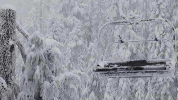 Chairlift no resort de esqui coberto de neve branca durante um dia de temporada de inverno nevado. — Vídeo de Stock