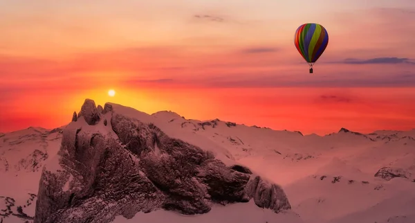 Dramatic Mountain Landscape covered in clouds and Hot Air Balloon Flying. — Fotografia de Stock