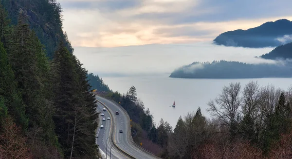 Sea to Sky Highway met auto 's en Howe Sound op de achtergrond bedekt met mist en wolken. — Stockfoto