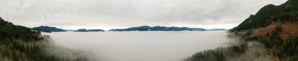 Панорамный вид с воздуха на Канадский горный ландшафт, покрытый туманом над озером Харрисон — стоковое фото