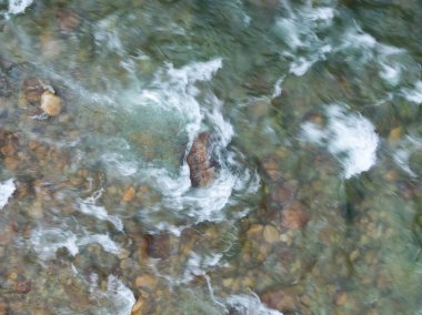 Taze suyun yukarıdan görünüşü kayaların etrafındaki dereden aşağı akıyor..