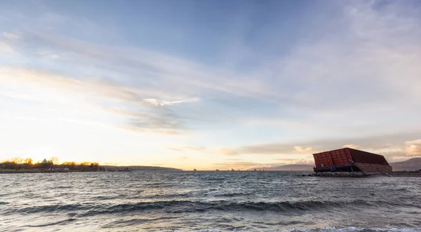 Barge containerschip botste op een rotsachtige kust tijdens de storm. Zonsondergang hemel. — Stockfoto