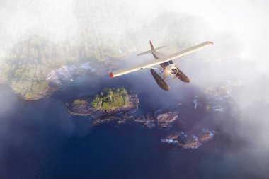 Gün batımında Batı Sahili Pasifik Okyanusu üzerinde uçan bir deniz uçağı..