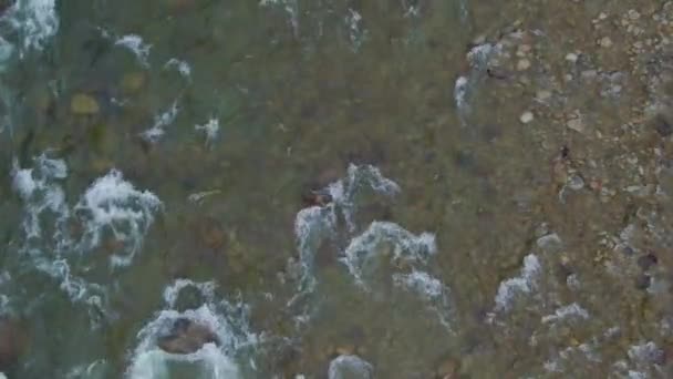 Vista aérea desde arriba de agua dulce que fluye por un arroyo fluvial alrededor de rocas. — Vídeo de stock