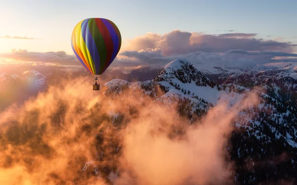 Dramatic Mountain Landscape covered in clouds and Hot Air Balloon Flying. — Stockfoto