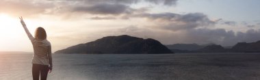 Pasifik Okyanusu 'nun batı kıyısında barış işareti olan bir kadın.