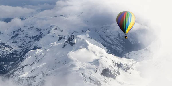 Dramatic Mountain Landscape covered in clouds and Hot Air Balloon Flying — Stockfoto