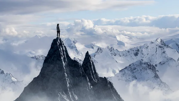 Mujer aventurera excursionista de pie en la cima del pico helado con montañas rocosas en el fondo. —  Fotos de Stock