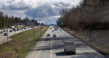 Güneşli ve bulutlu bir kış gününde Trans-Kanada Otoyolu 'nda Arabalar Sürülüyor