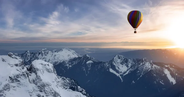Dramatische berglandschap bedekt met wolken en hete lucht ballon vliegen. — Stockfoto