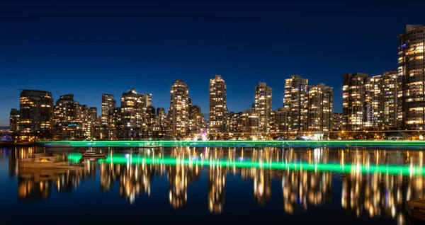 Falsk bäck med moderna stadsbyggnader på natten efter solnedgången. — Stockfoto