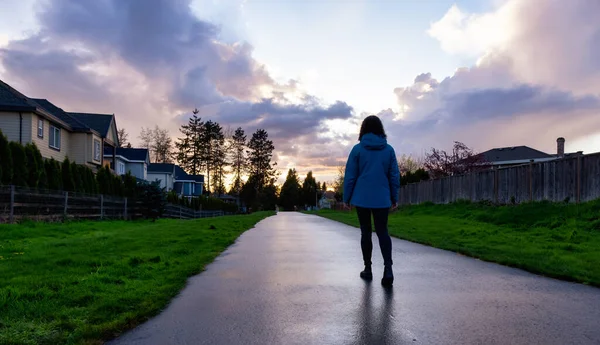 Woman walking on a path in a residential neighborhood of modern city suburbs. — Stockfoto