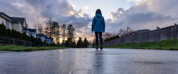 Woman walking on a path in a residential neighborhood of modern city suburbs. — Stockfoto