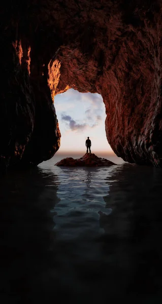Abenteuerlustiger Mann steht in einer Felshöhle am Meer. — Stockfoto